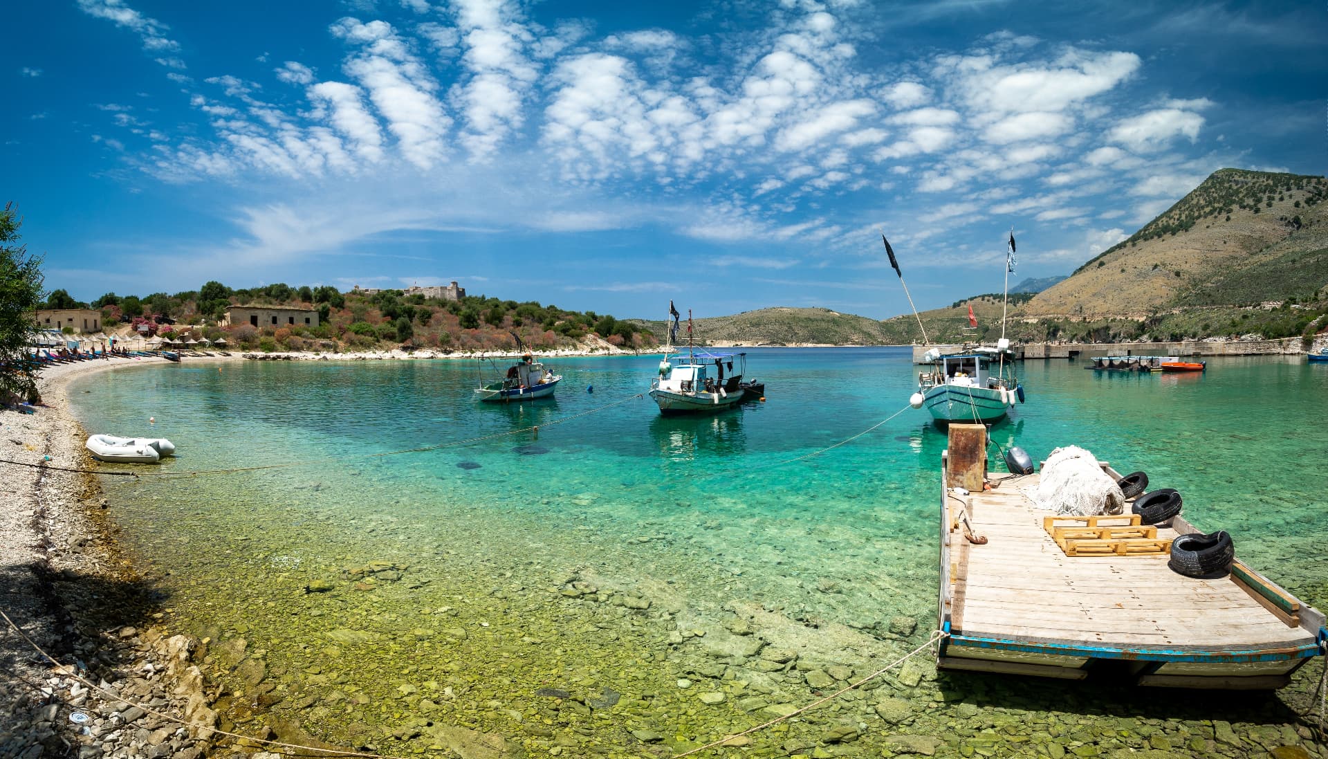 Albanian coastal village on a green hillside above the sea